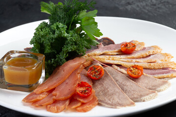 Meat delicacies on plate. On a gray background.