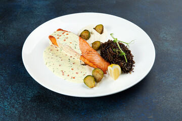 Salmon steak and black rice in a bowl.