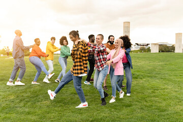 Multi-ethnic group of friends having fun dancing together outdoors during summer vacation fun young...