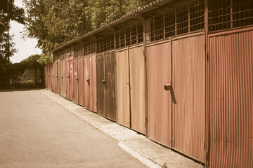 Old rusty garages in a row with rust and striped doors