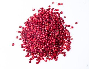 pile of pink peppercorns isolated on white background (top view)