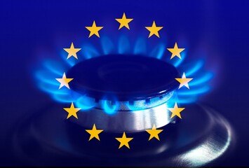The blue flame of a gas stove in the dark. Gas burner on the background of the flag of the European...