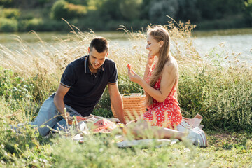 Young happy loving couple embracing and having fun together outdoors. Young couple in love on summer picnic