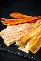 salty dried fish snacks for beer on a dark background