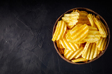 golden crispy potato chips on a dark background