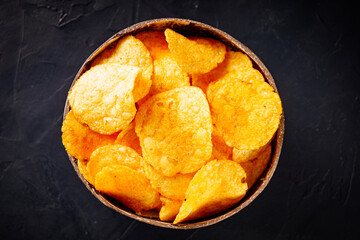golden crispy potato chips on a dark background