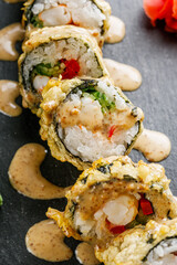 delicious sushi rolls on a black stone background