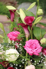 Fototapeta premium Rosa Calla und Rosen in einem Gesteck nach Beerdigung auf dem Friedhof