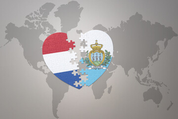 puzzle heart with the national flag of san marino and netherlands on a world map background.Concept.