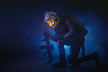 Spaceman or star trooper in the helmet and with rifle in the blue smoke. Science fiction concept.