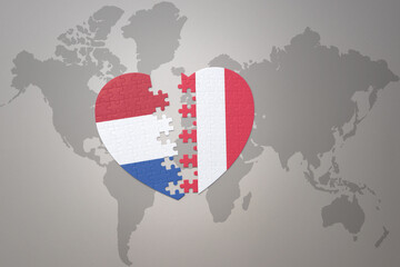 Fototapeta premium puzzle heart with the national flag of peru and netherlands on a world map background.Concept.