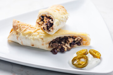 beef burrito with rice and beans served with whipped cream and jalapenos