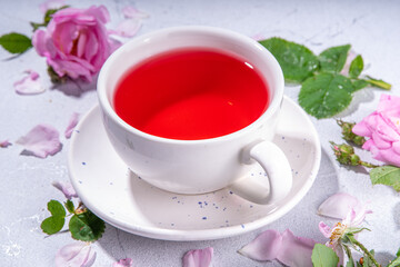 Rose buds tea, organic floral herbal hot tea drink with fresh rose flowers, in tea pot and cup, copy space