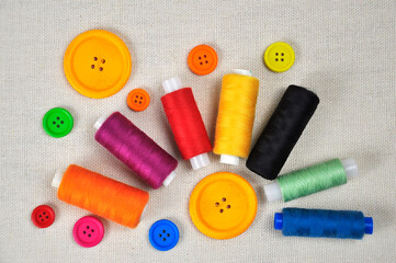 Sewing thread spools and multicolored buttons.