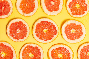 Grapefruit slices set on yellow background