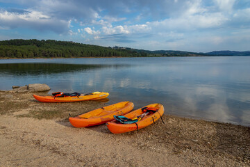 three orange kayaks at the Vilar Dam in Moimenta da Beira, Viseu, Portugal