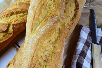 Bread on a wooden table and on a cloth, overhead view.