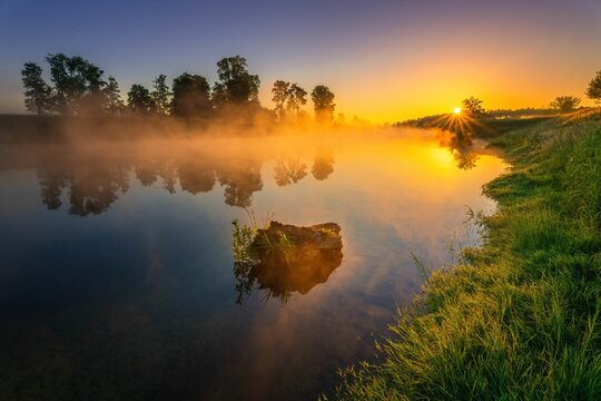 Fototapeta Wschód słońca nad rzeką Wartą. Słońce, mgła i rzeka o świcie
