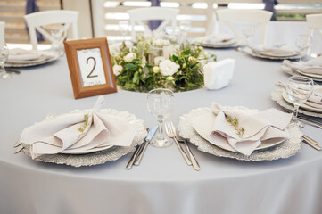 A very beautiful festive table with candles, plates and glasses. Cool room decor