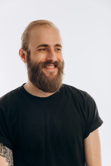 portrait of a young guy with a beard in a black T-shirt on a white background. hipster