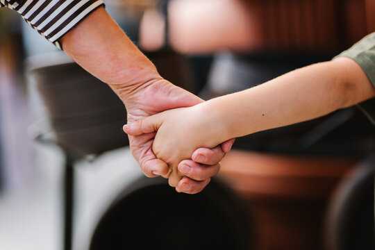 Crop grandparent and grandchild holding hands