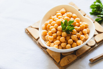 Cooked chickpeas in white bowl. Ingredient for Tasty vegetarian food. Boiled chickpeas, selective focus