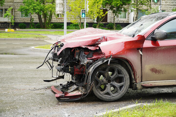 Wrecked car on the edge of a wet road. The concept of reckless driving in difficult weather...