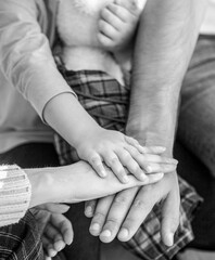 Closeup of baby hand into parents hands. Concept of unity, support, protection, happiness. Child hand closeup into parents. Hands of father, mother, keep hand little baby. Parents hold the baby hands