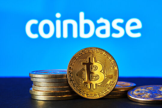 Coinbase logo on a computer screen with a stack of crypto coins