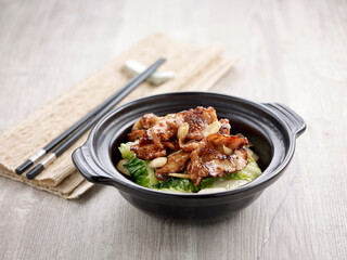 Stir-fried Tender Pork Collar with Supreme Soya Sauce with chopsticks served in a pot isolated on mat side view on grey background