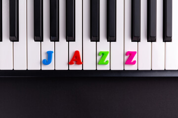 The word Jazz is composed of multicolored letters on the piano keys. Copy space.	