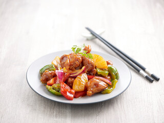 Sweet and Sour Pork with chopsticks served in a dish isolated on mat side view on grey background