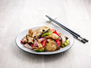 Stir-fried Sliced Fish with Black Bean Sauce with chopsticks served in a dish isolated on mat side view on grey background
