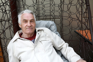 Senior man resting in hanging chair