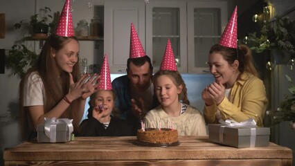 family celebrating birthday. Happy family family party. Little child girl blows out candles on cake. Happy birthday of child. Family holiday. Birthday cake with candles - Powered by Adobe