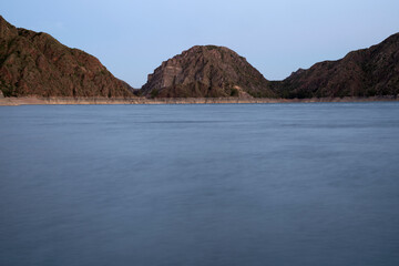 Night shot. View of the lake and mountains at nightfall. Beautiful blurred water effect and color.