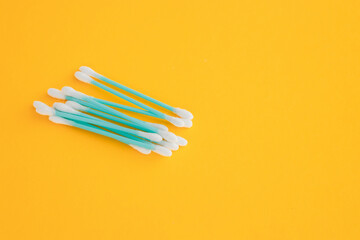 Flat lay composition with cotton swabs on yellow background. Top view ear sticks