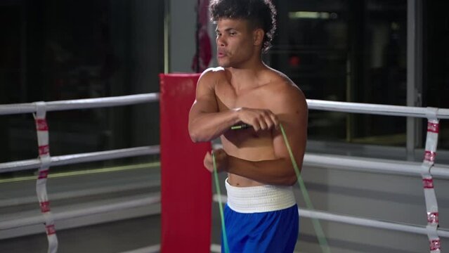 afro-american sportsman is warming body before training, jumping with skip rope, fitness exercises