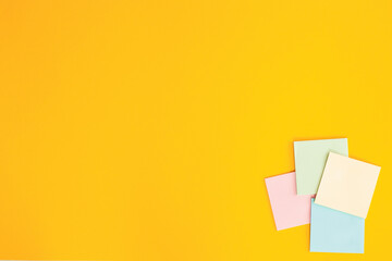 Blank colorful sticky notes on yellow background, flat lay.