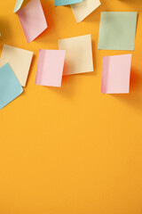 Blank colorful sticky notes on yellow background, flat lay.