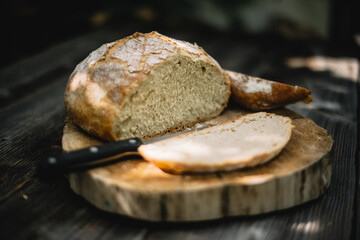Traditional leavened sourdough bread cut into slice on a rustic wooden table. Healthy food photography