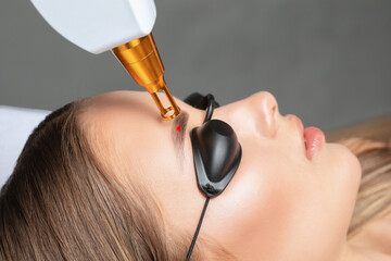 Removal of permanent makeup on the eyebrows.Carbon face peeling in a beauty salon. Hardware...