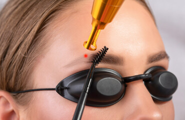 Removal of permanent makeup on the eyebrows.Carbon face peeling in a beauty salon. Hardware...