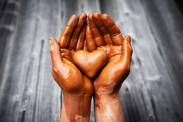 Heart made of potter's clay in the hands of a master potter. Love concept