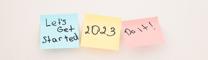 A sticky note with the year 2023 on white wall. Close up. New year. New chance