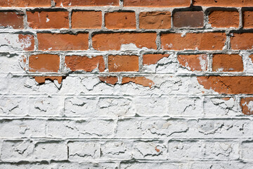 Grunge brick wall background with aging texture closeup. White and orange bricks