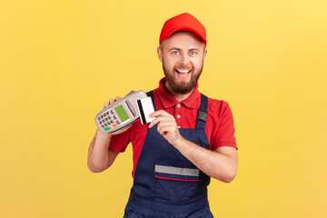 Excited joyful bearded worker man holding pos terminal for contactless payment and credit card,...