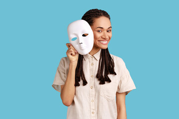 Woman with dreadlocks removing white mask from face showing his smiling expression, good mood,...