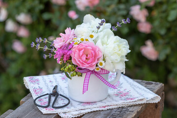 romantischer Blumenstrauß mit pink Rosen und weißen Pfingstrosen in Emaille-Tasse