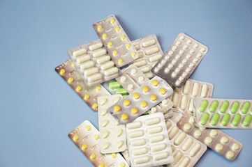 A lot of medicines on a blue background.Pills in blister packs. Close-up. Medicine, drugs, vitamins, pharmaceuticals, pharmacy.